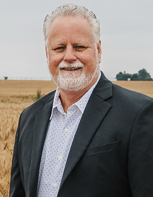 Man with wavy grey hair wearing a black shirt