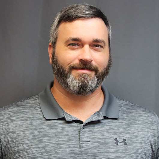 Bearded man in grey polo shirt