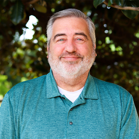Man with a beard wearing a blue polo shirt