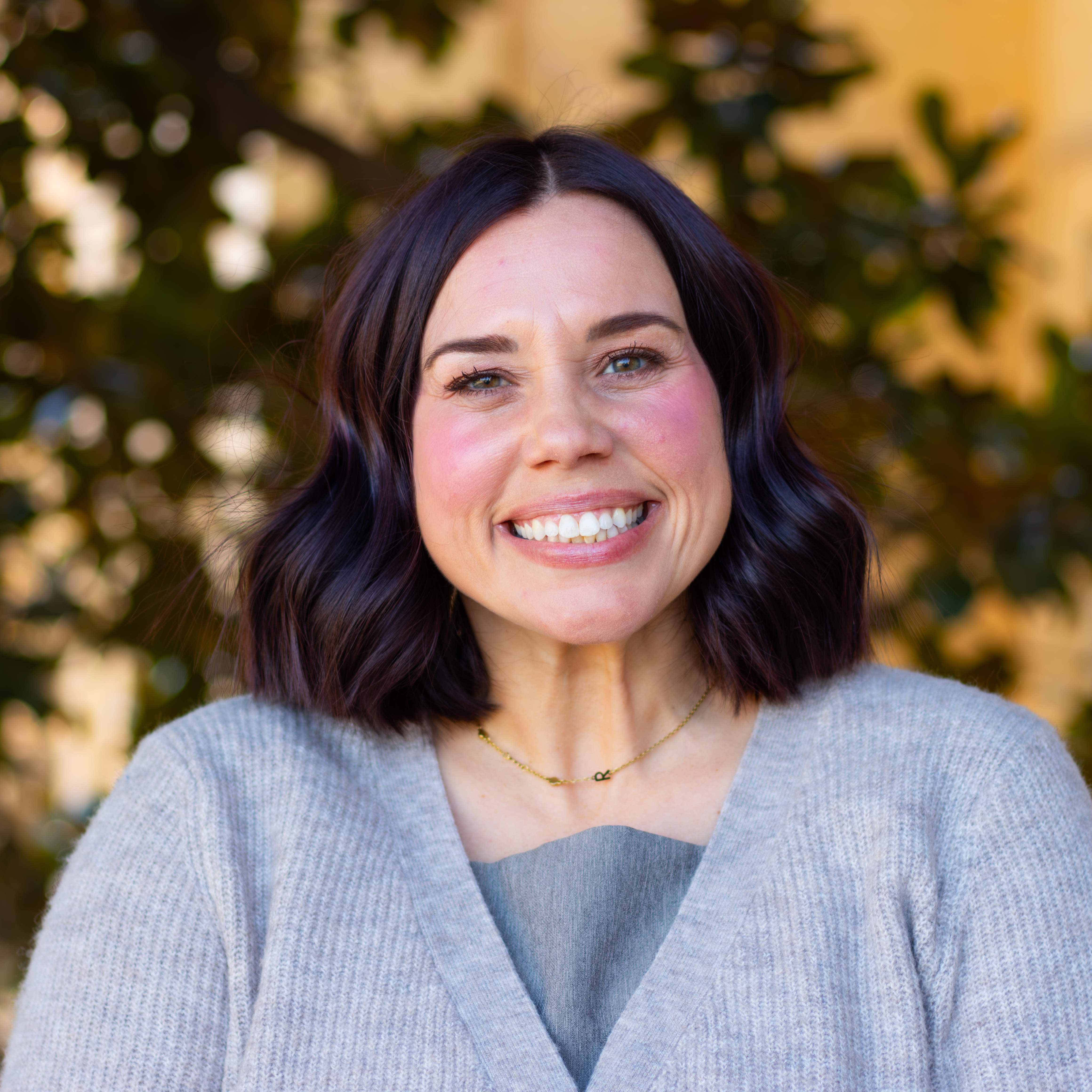 Woman smiling in pastel purple sweater