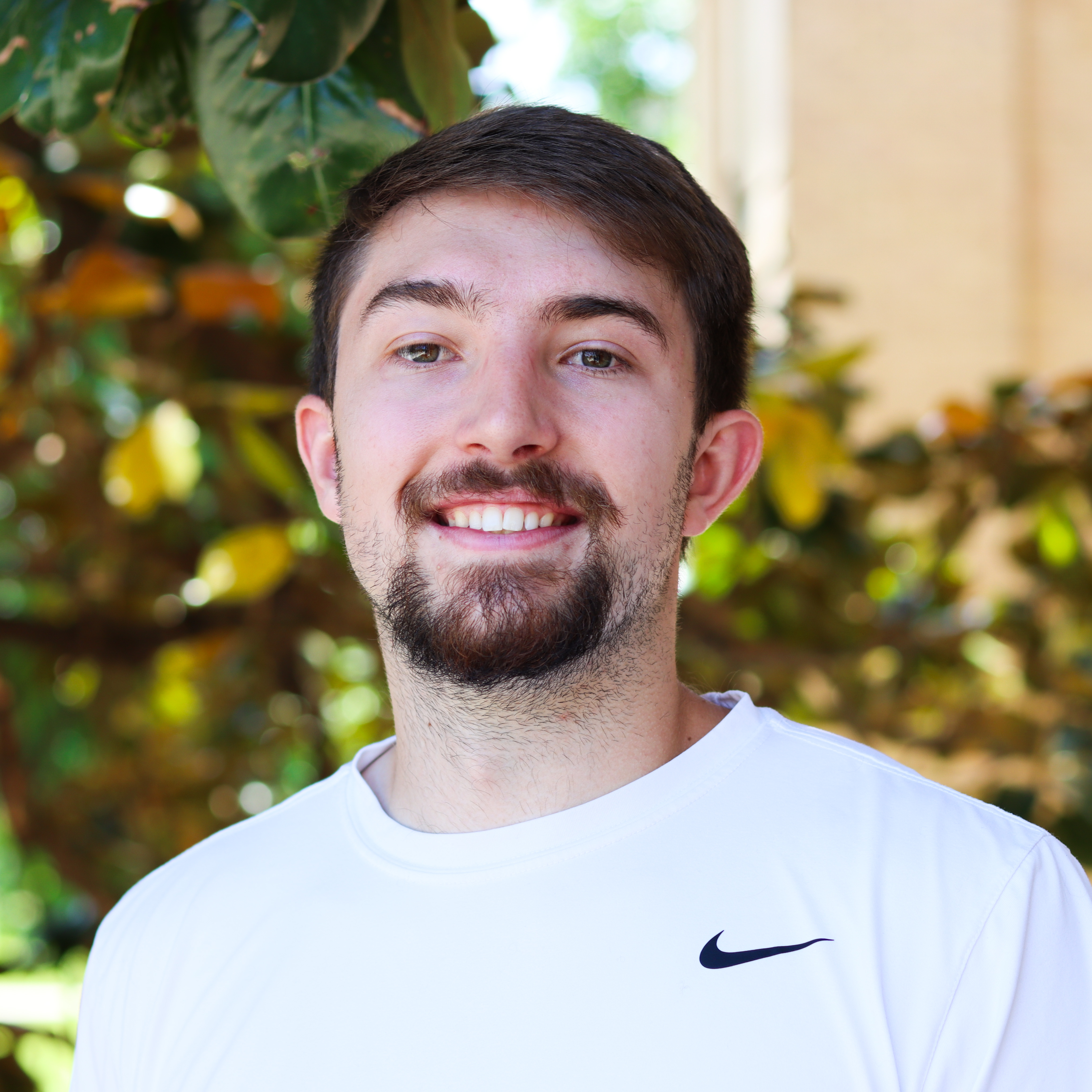 Josh Price smiling in a white shirt