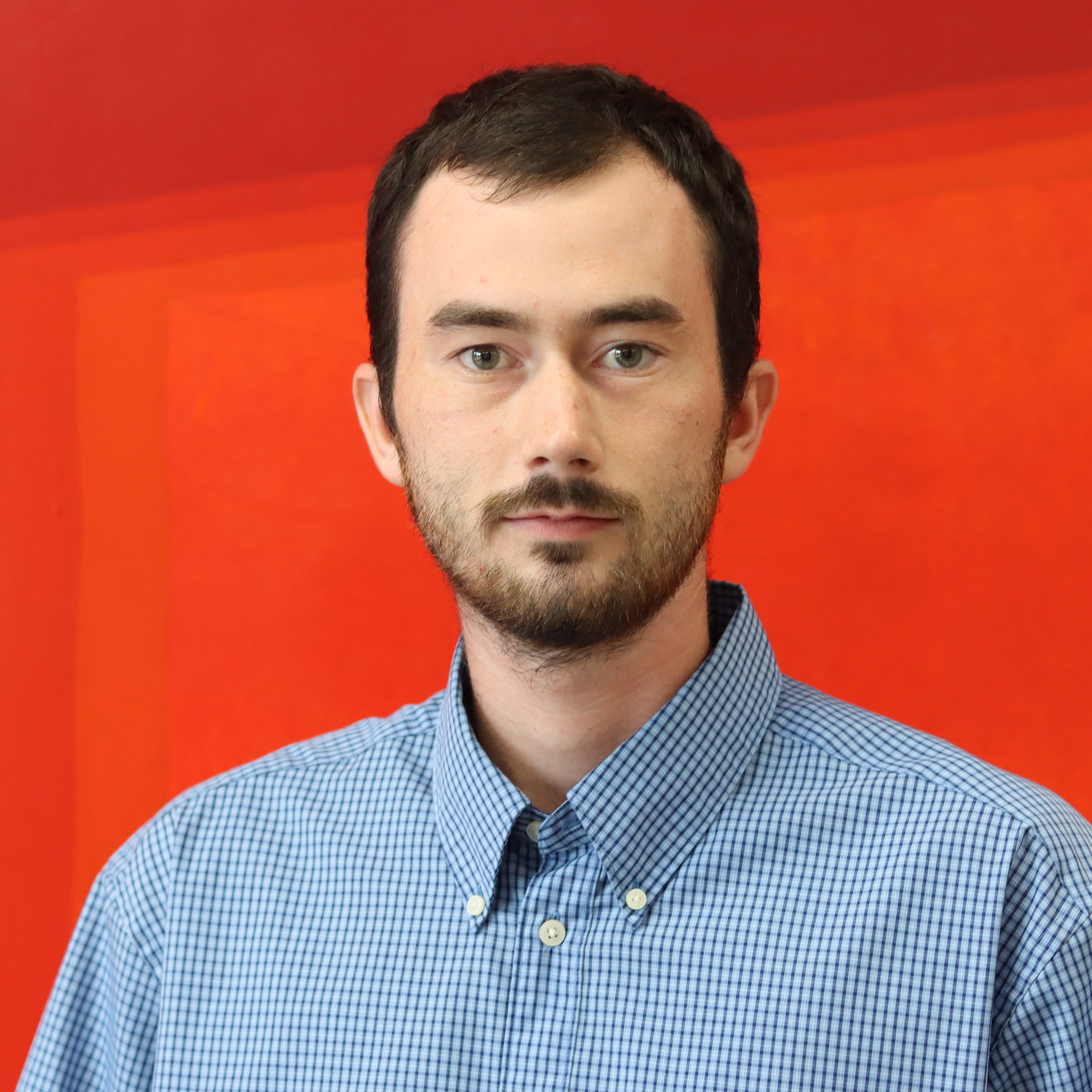 Rilley Merrill standing in front of a red background